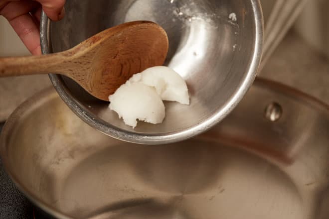 Coconut oil being placed in a pan