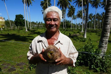 A man posing with a coconut